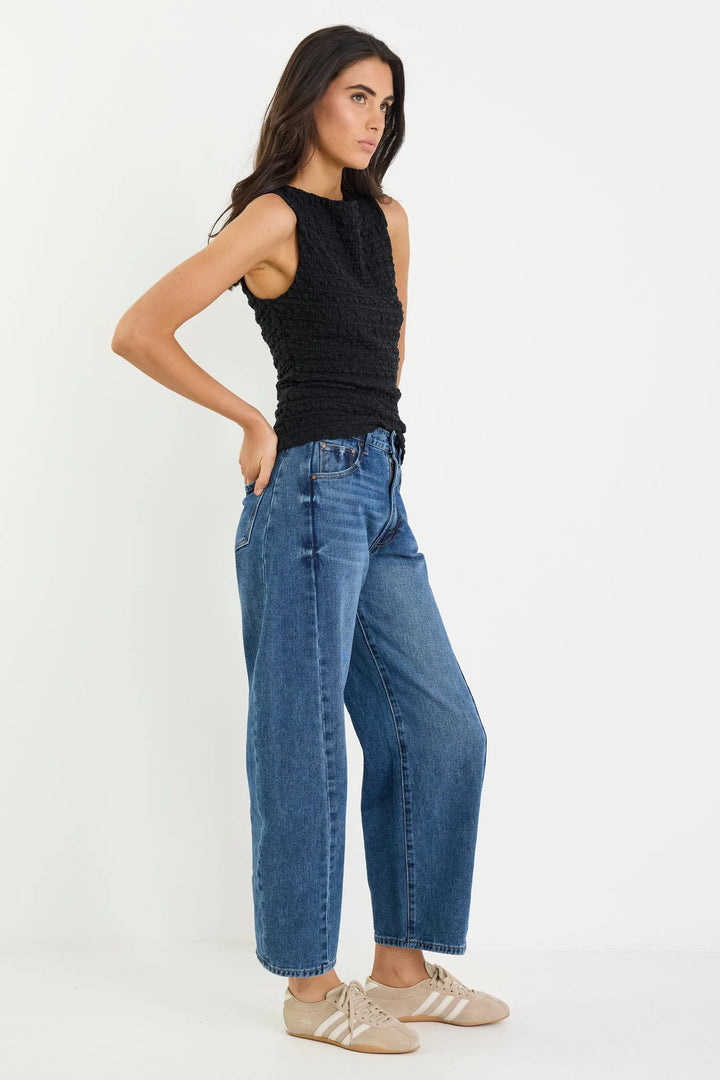 side view of dark blue barrel jean