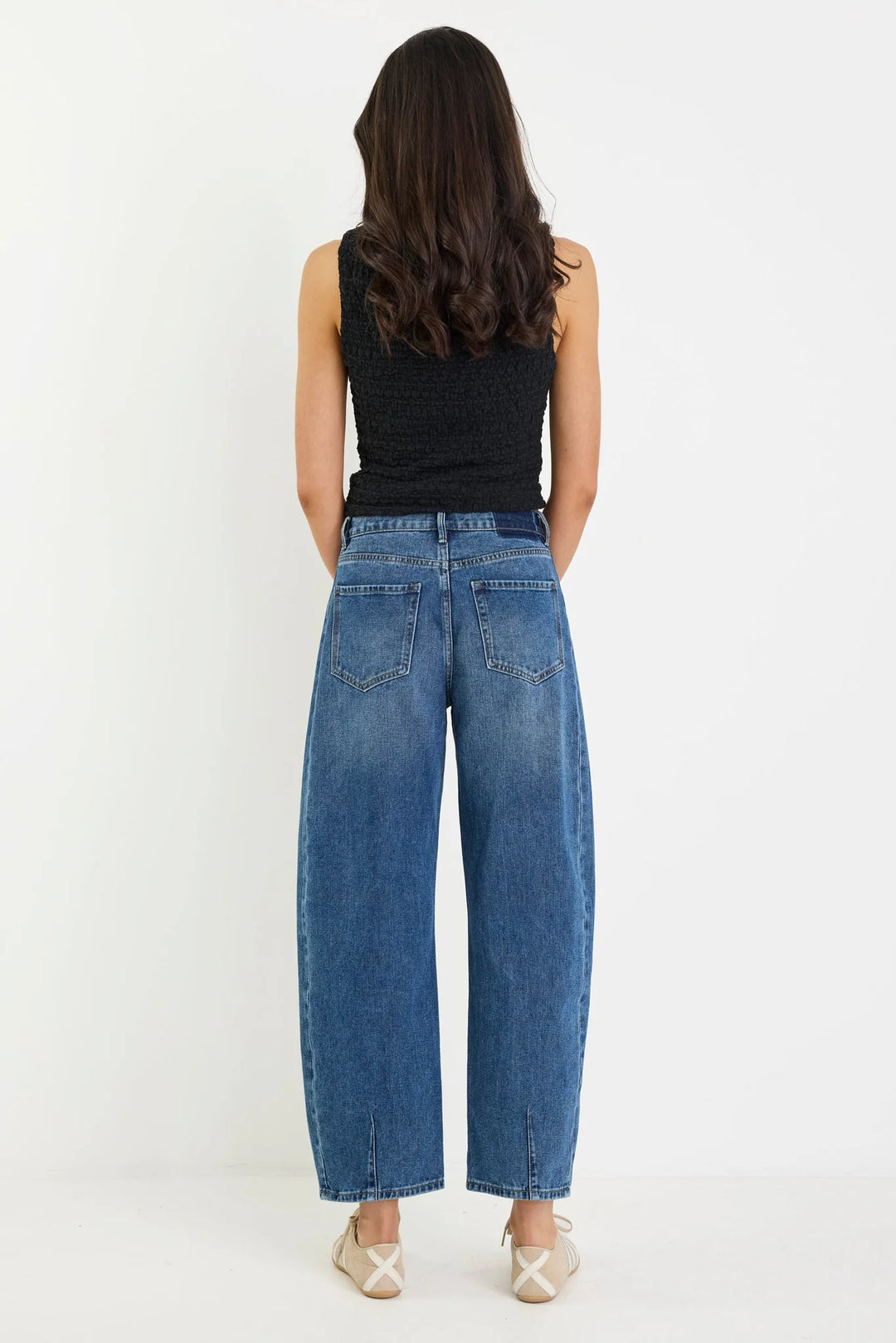Back view of the deep blue barrel leg jean