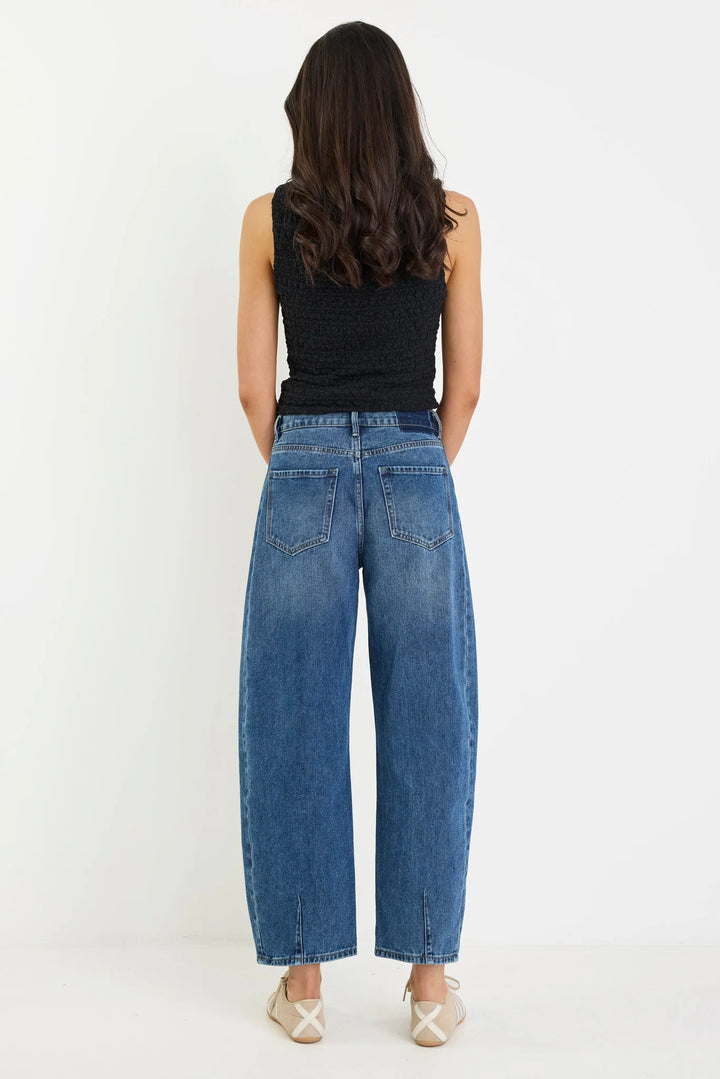 Back view of the deep blue barrel leg jean